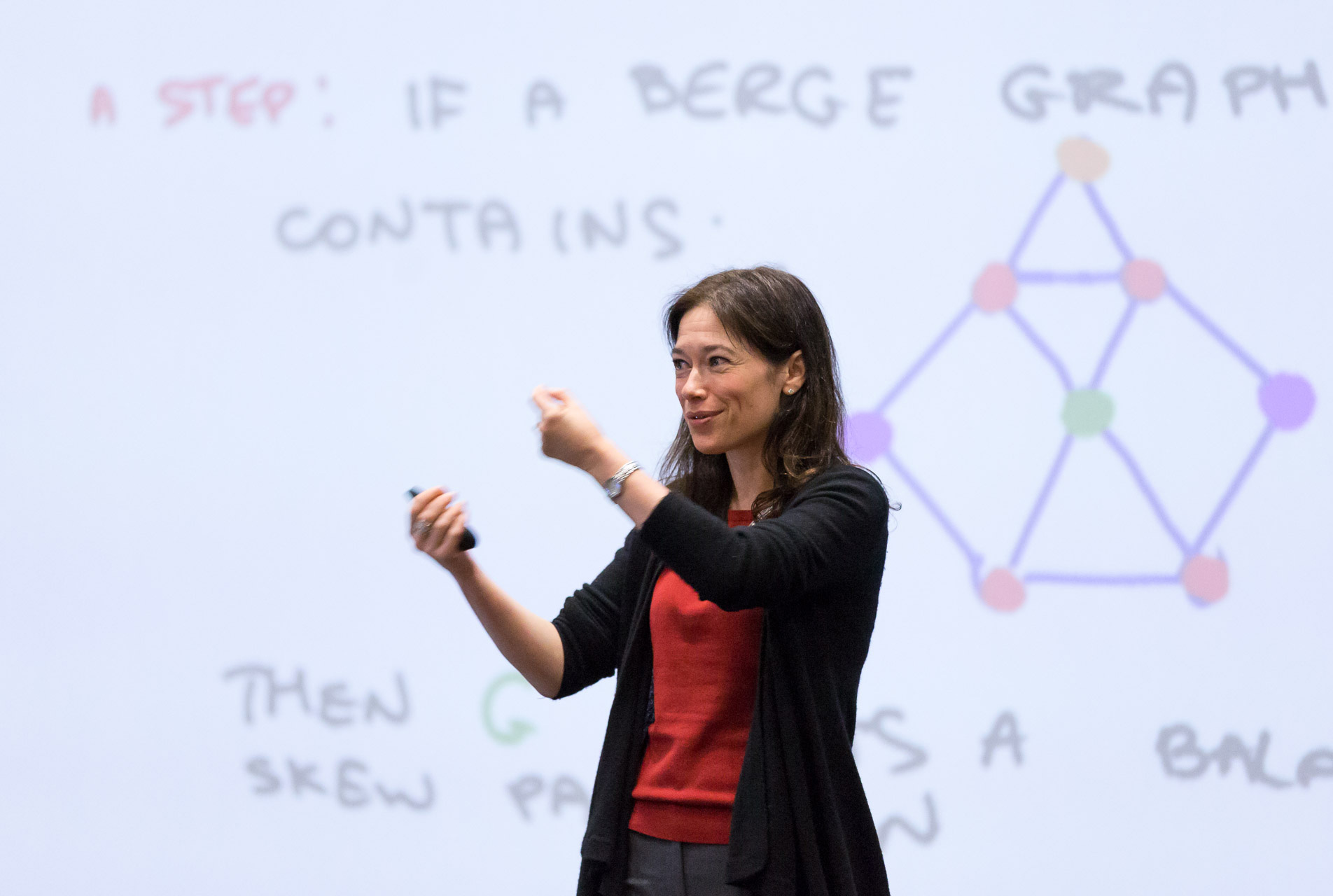 Photo of Maria Chudnovsky standing in front of a whiteboard