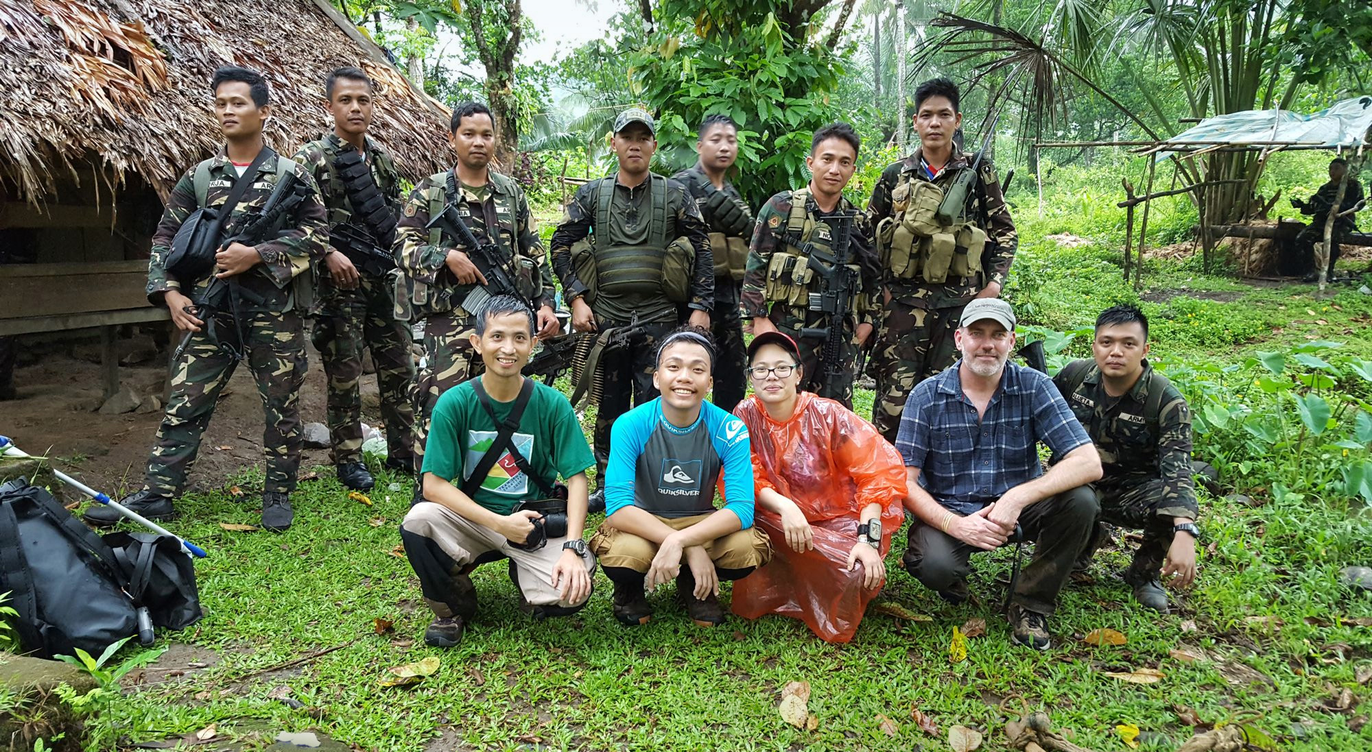 Jeanmaire Molina and her team posing for a photo with soldiers guarding them.