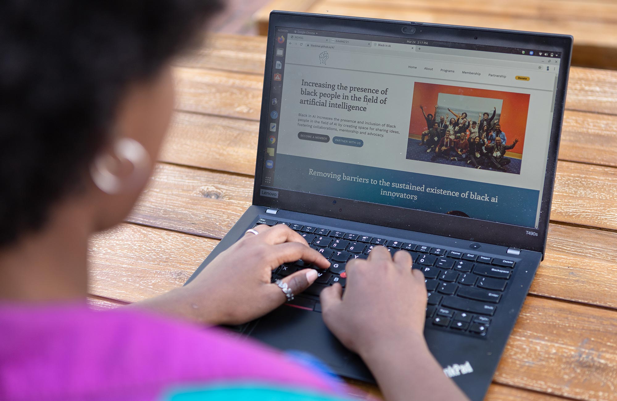 A diptych. On the left, Rediet Abebe sitting outside working on a laptop. On the right, a close-up of Abebe's laptop screen showing an article on increasing the presence of Black people in the field of artificial intelligence.