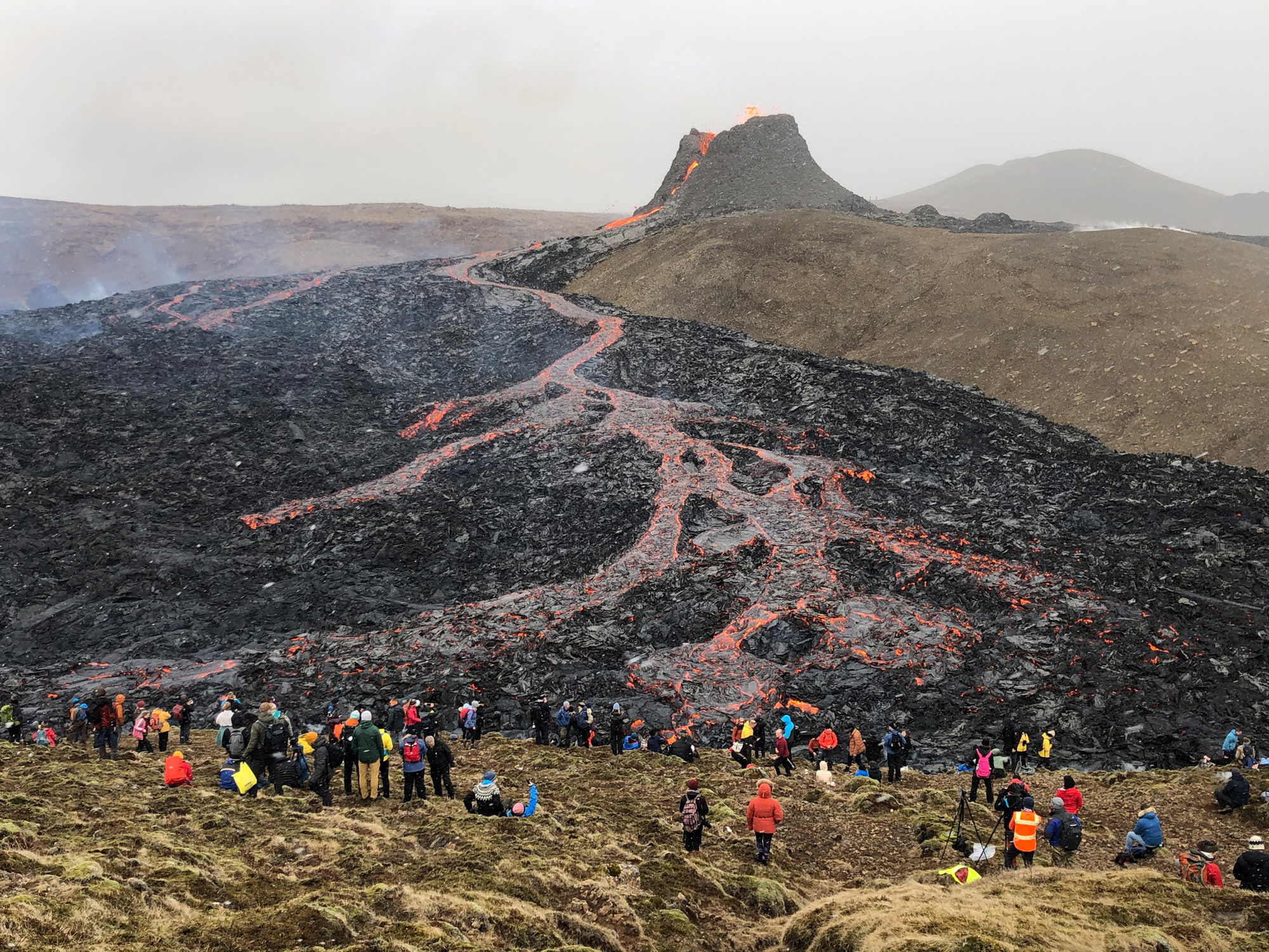 Onlookers staring at a lava flow.