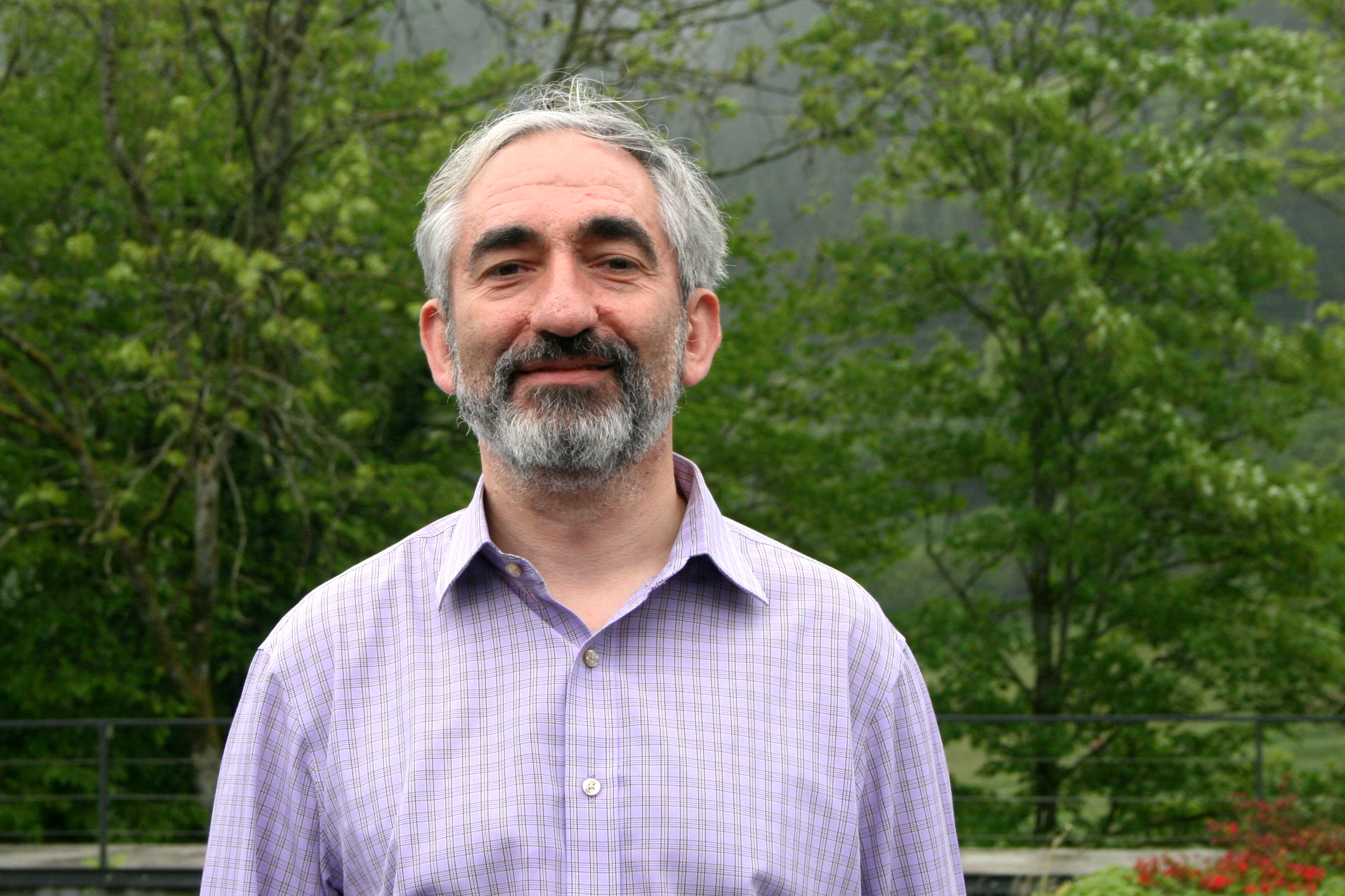 An outdoor photo of Michael Krivelevich in a purple shirt; a photo of Asaf Ferber in a green shirt sitting at a laptop