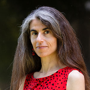 Woman in front of a blue curtain.