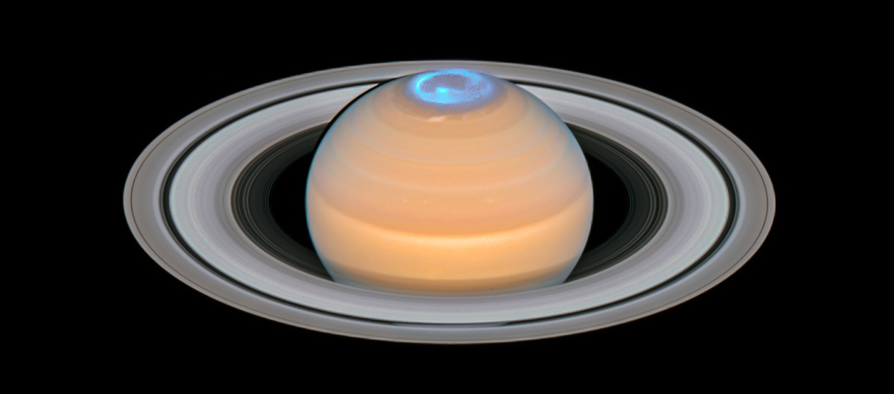 Saturn with glowing blue auroras.