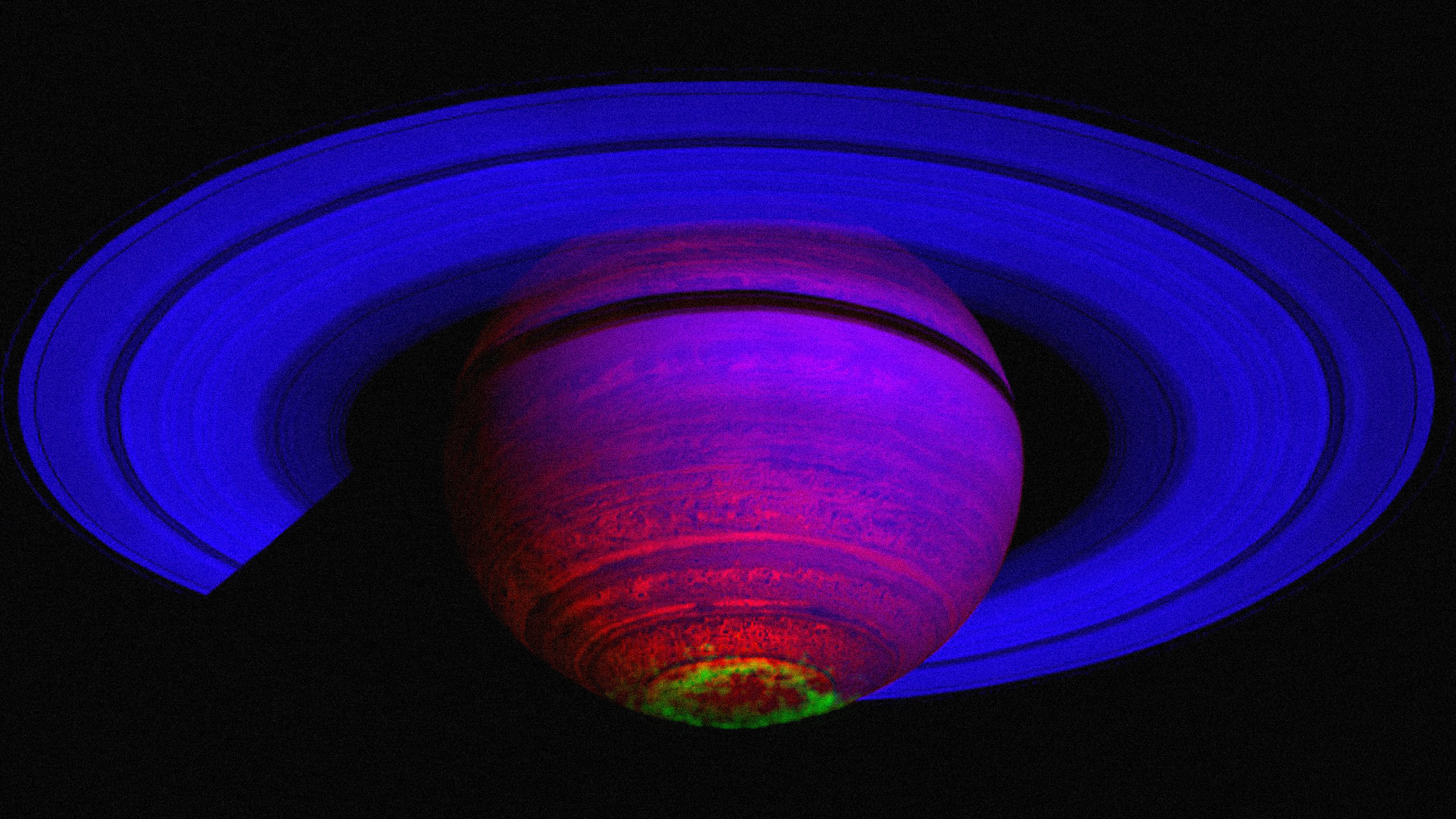 The ringed planet Saturn showing its aurora in green.