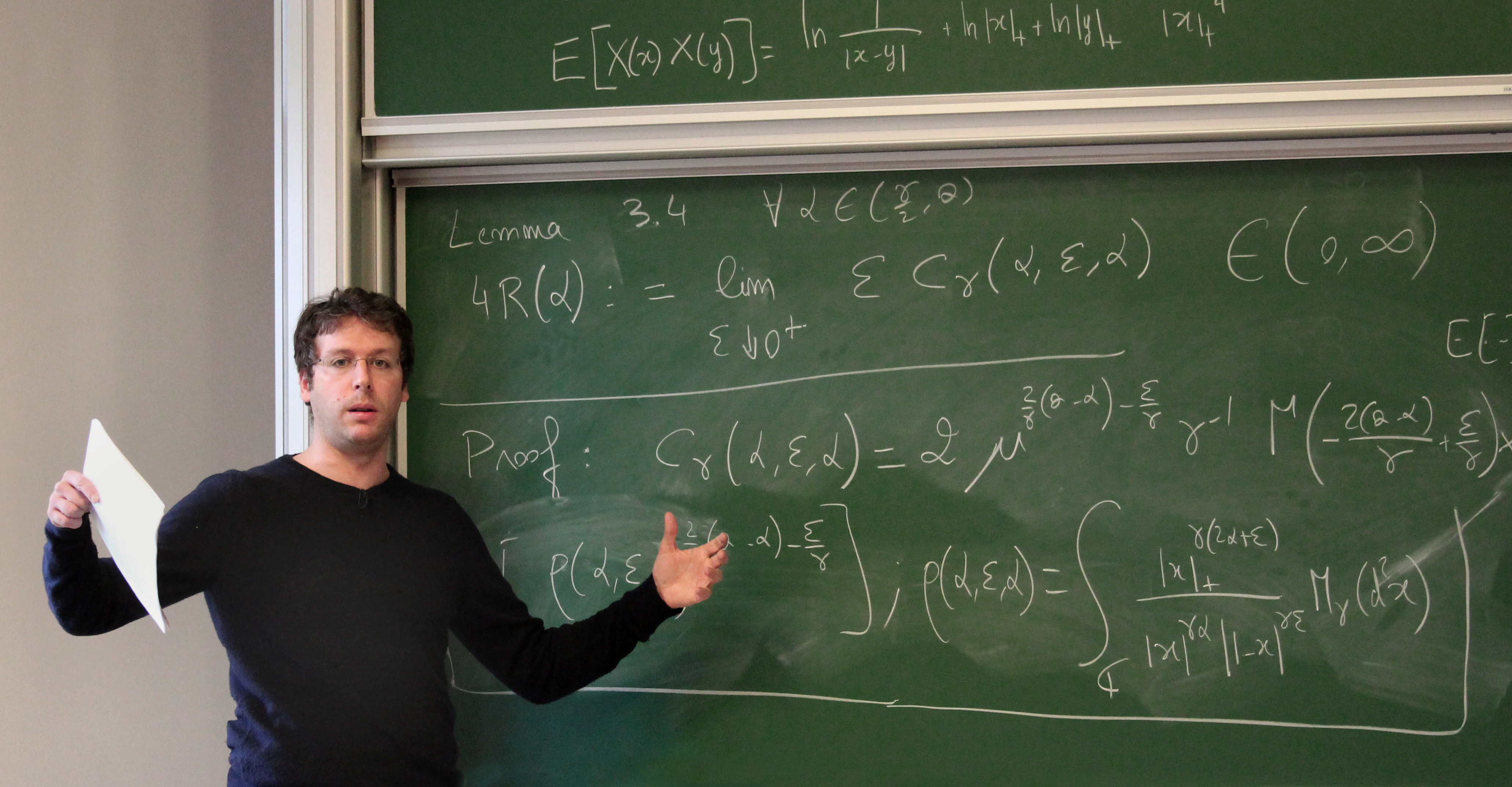 Vincent Vargas lecturing in front of a chalkboard.