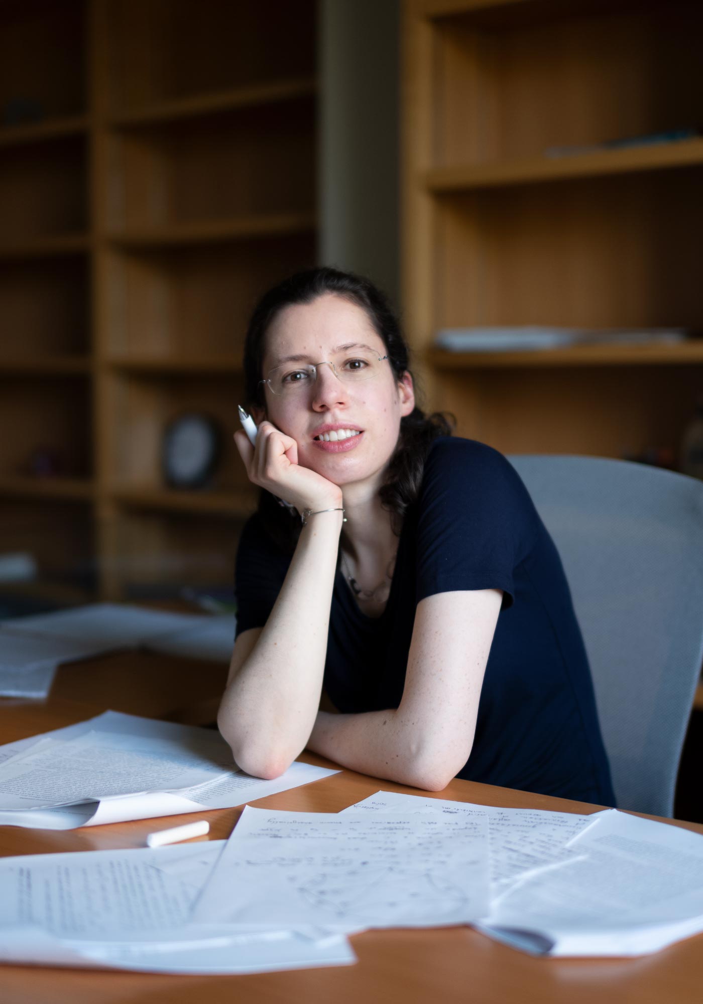 Engelhardt sitting at her desk, smiling at the camera with her chin resting on her palm.