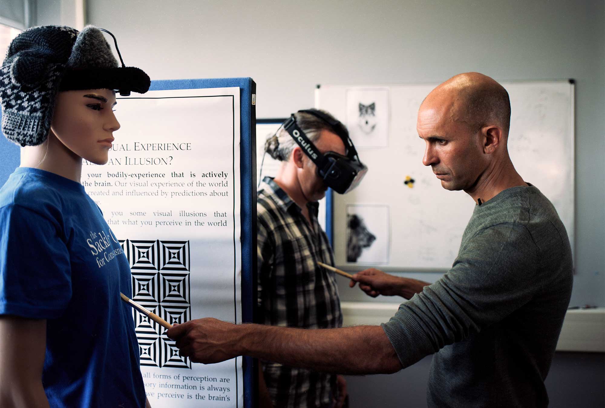 Seth touches a mannequin and a volunteer wearing a virtual reality headset.