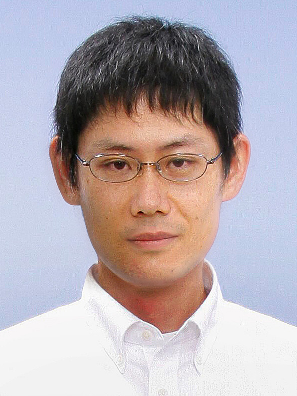 Photo of Tadayuki Watanabe in a white shirt against a gray background