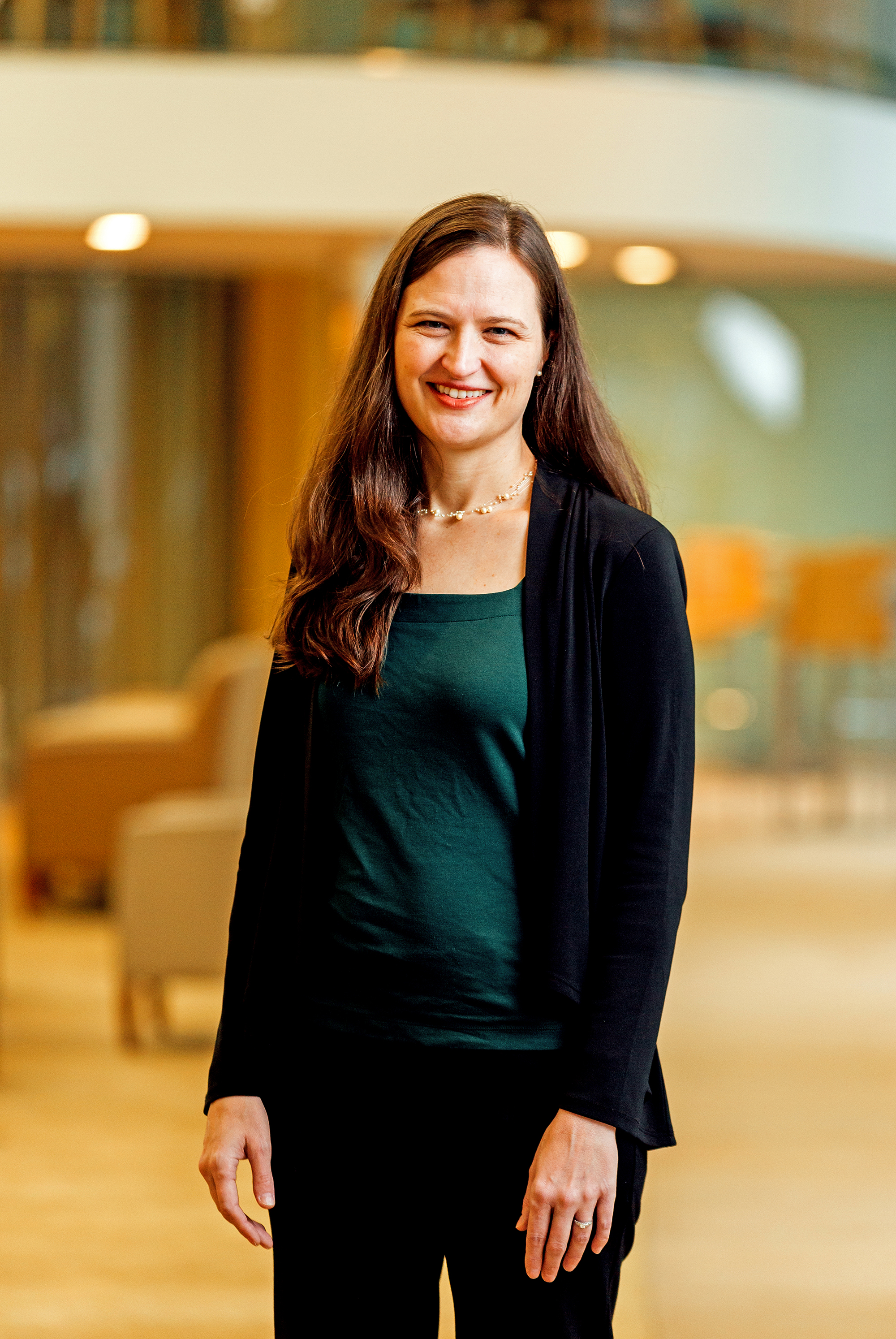 Photo of Anne Carpenter walking inside the Broad Institute.