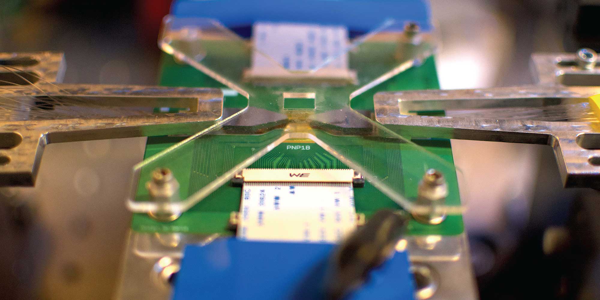 Close-up photo of a green computer chip mounted into lab machinery