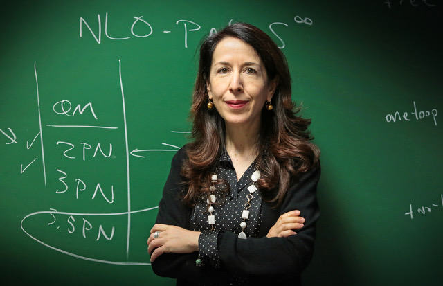 A woman in front of a green chalkboard.