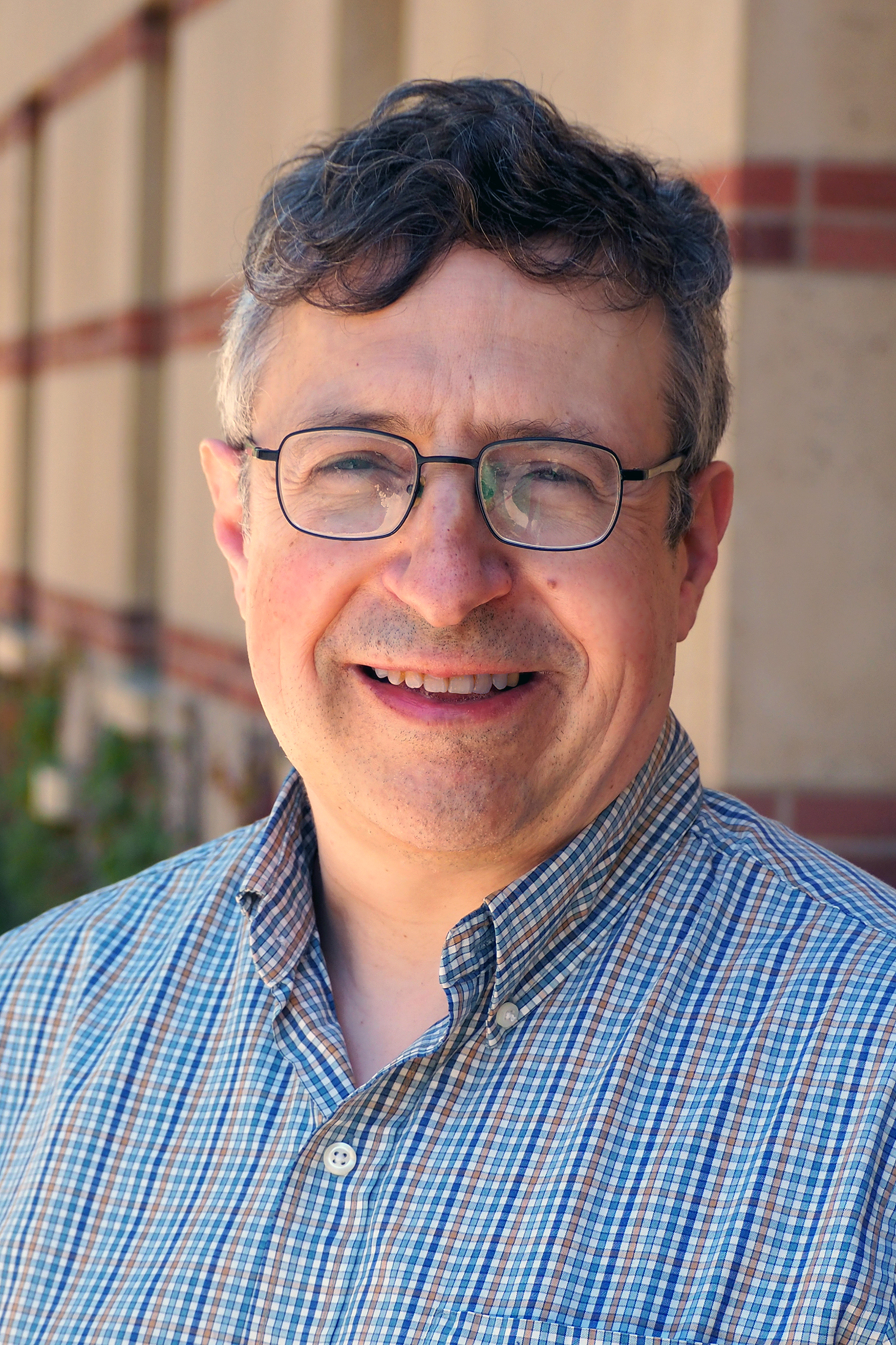 A man in a blue shirt and glasses.