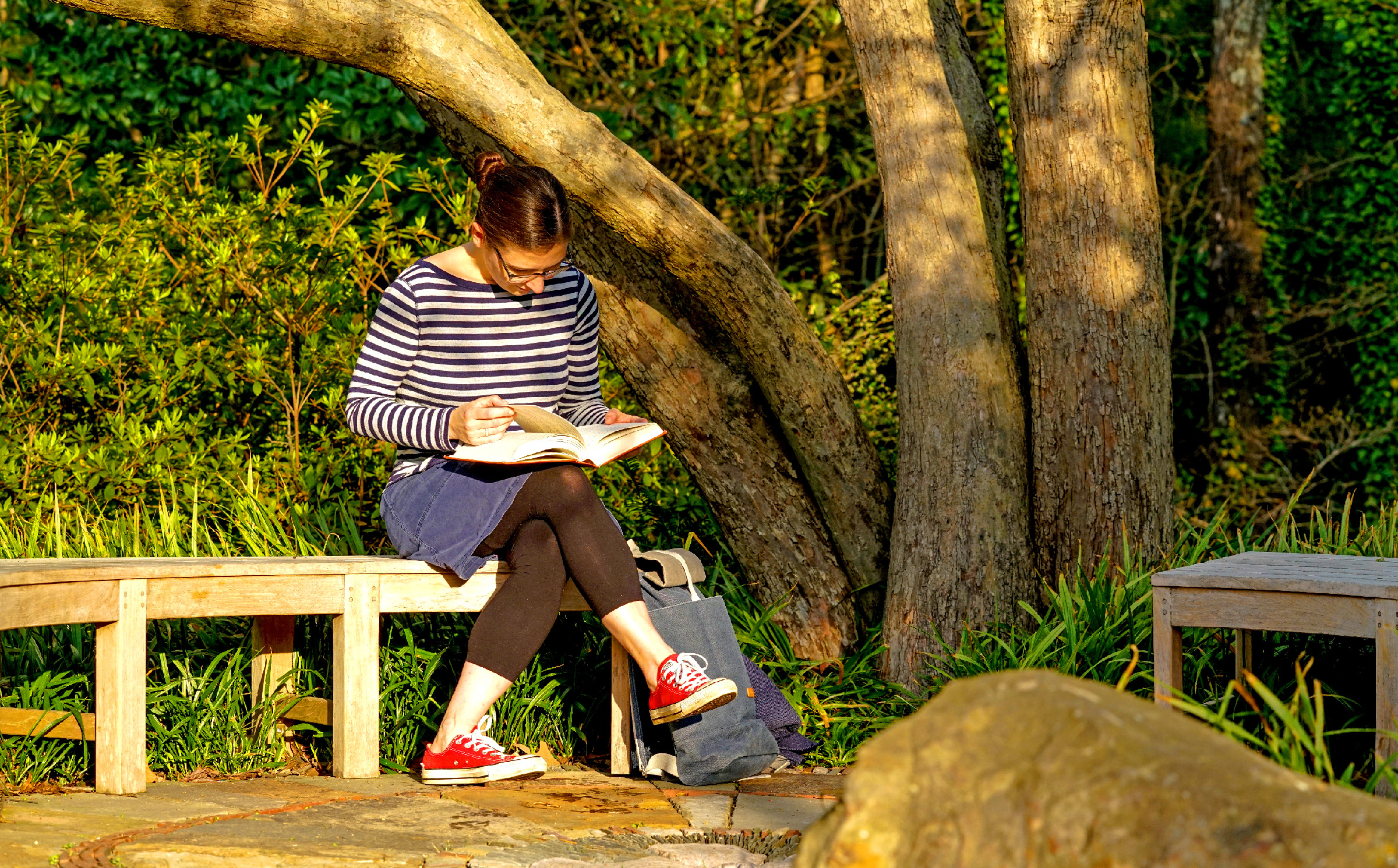 Lillian Pierce reading on a bench.