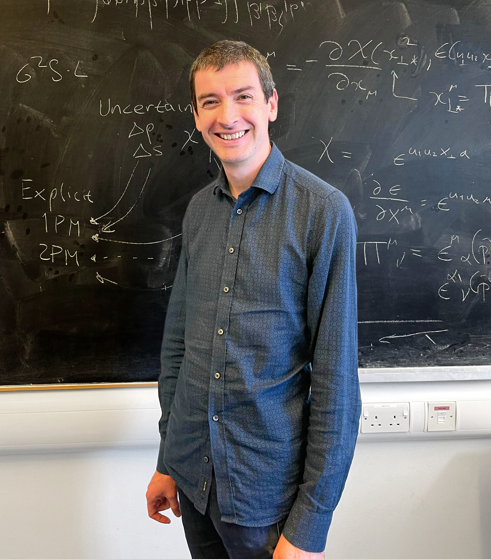 A man in front of a chalkboard.