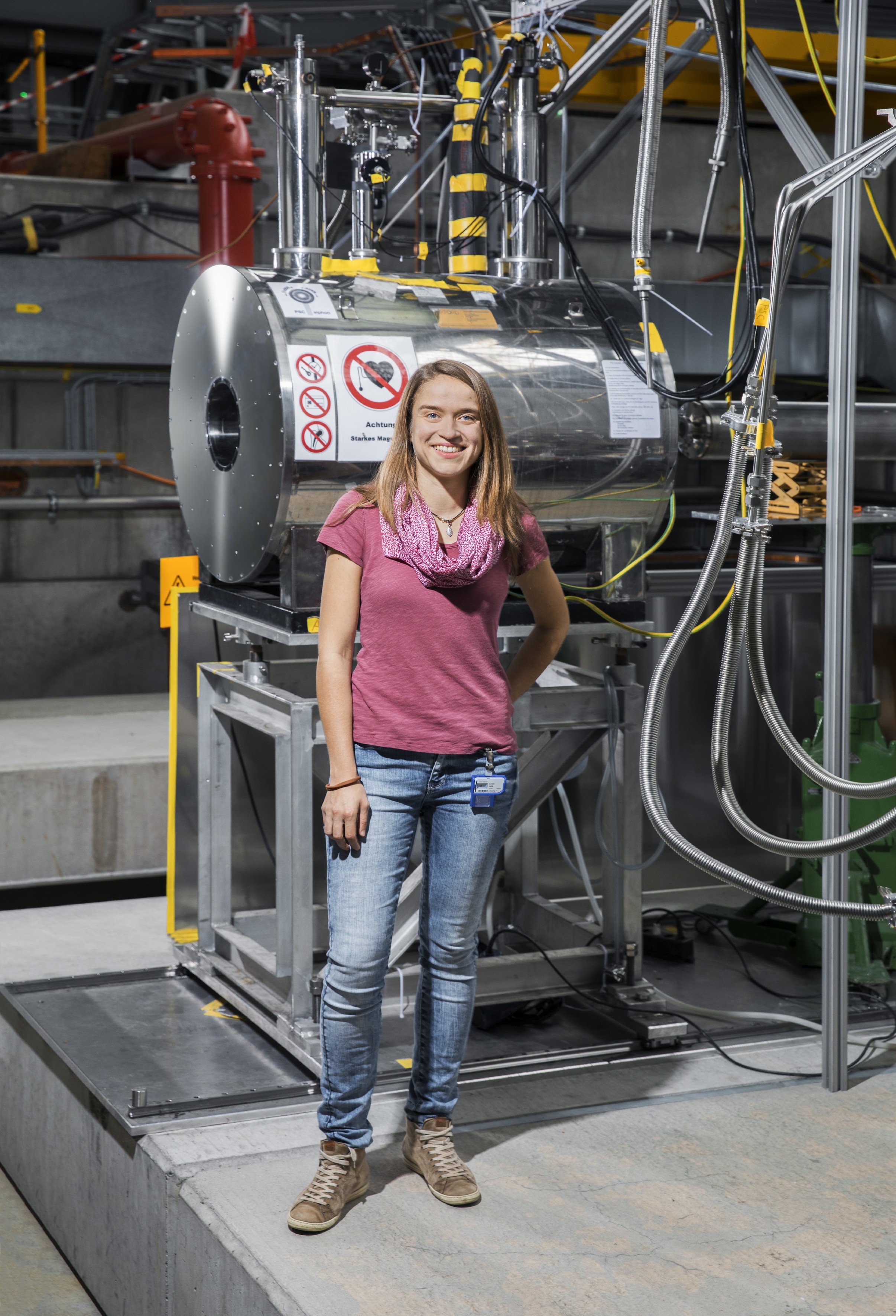 Alt text: Anna Sótér smiling in front of lab equipment.