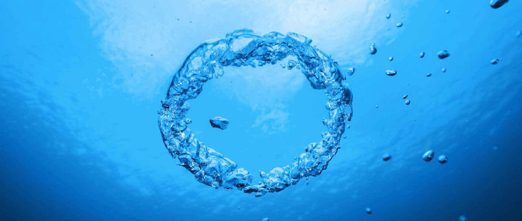 A ring of bubbles in blue water.