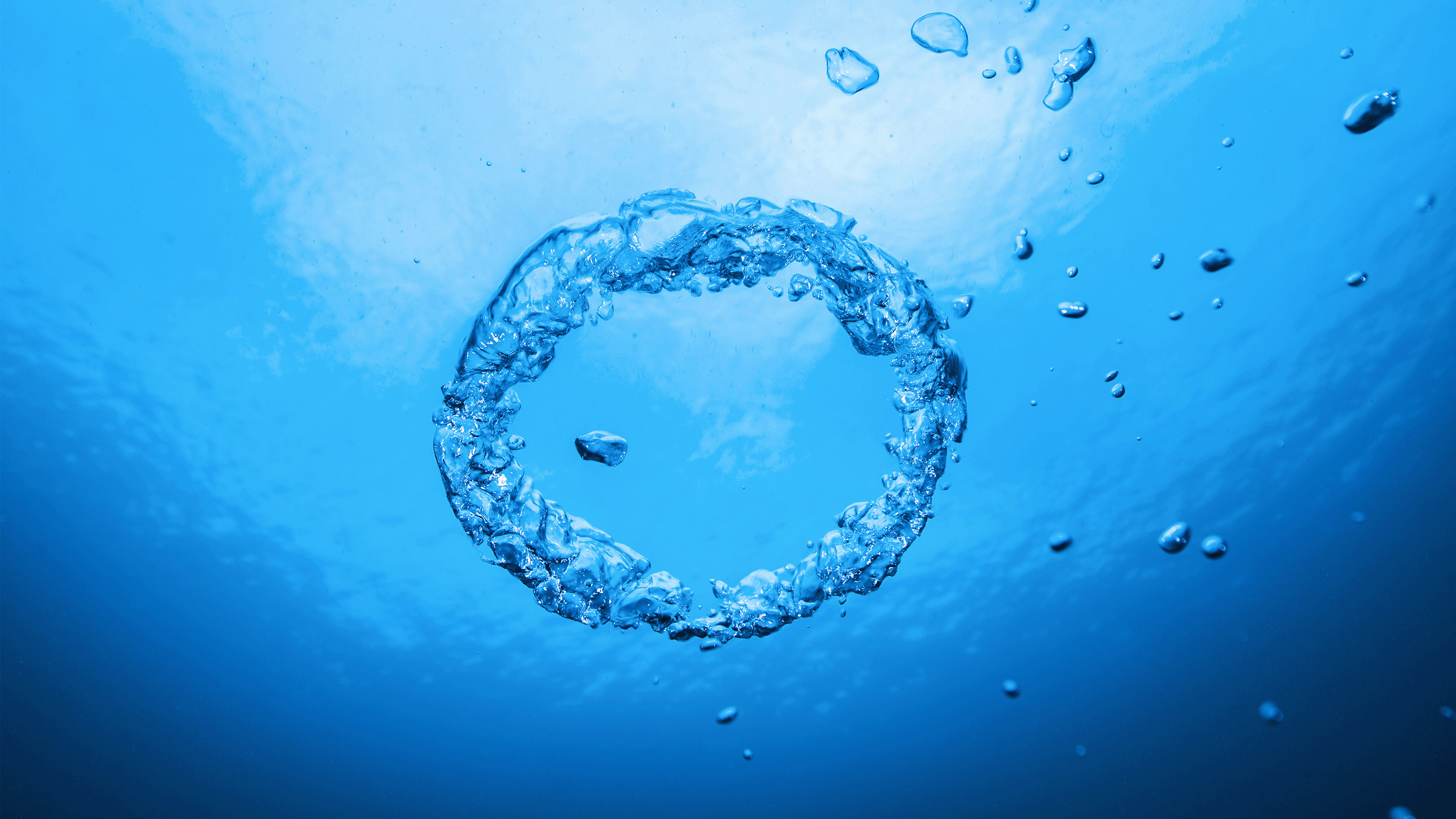 A ring of bubbles in blue water.