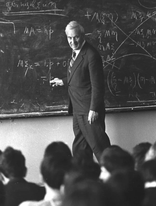 Historical photo of Andrey Kolmogorov at a chalkboard in front of multiple students.