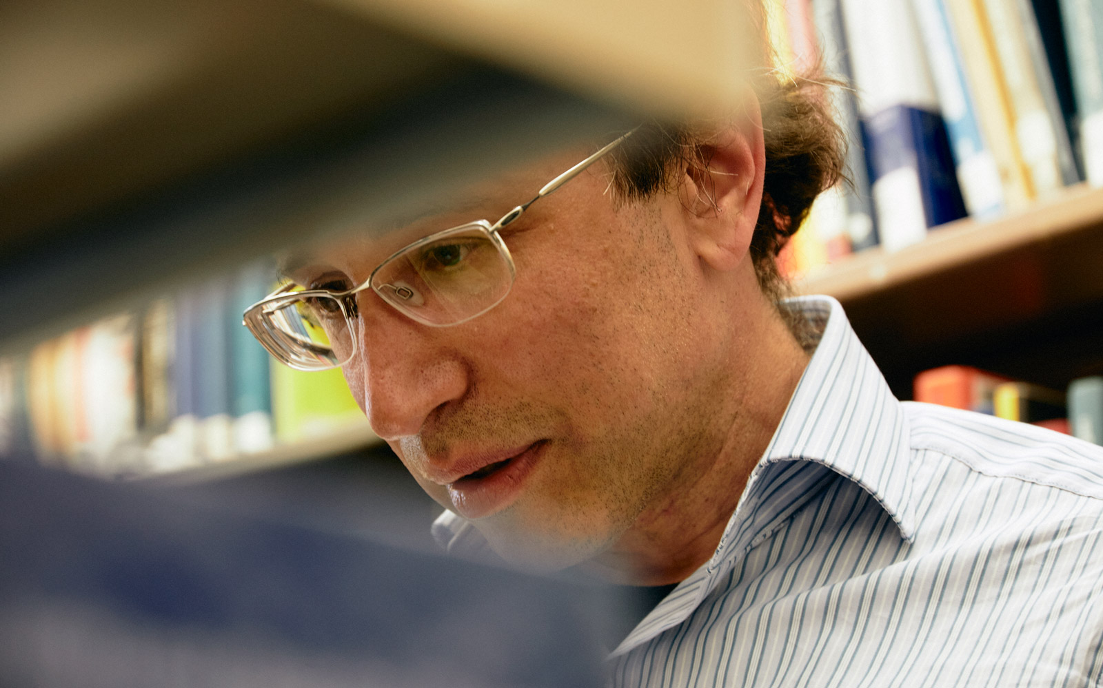 Daniel Spielman, partially obscured, in front of shelves of books