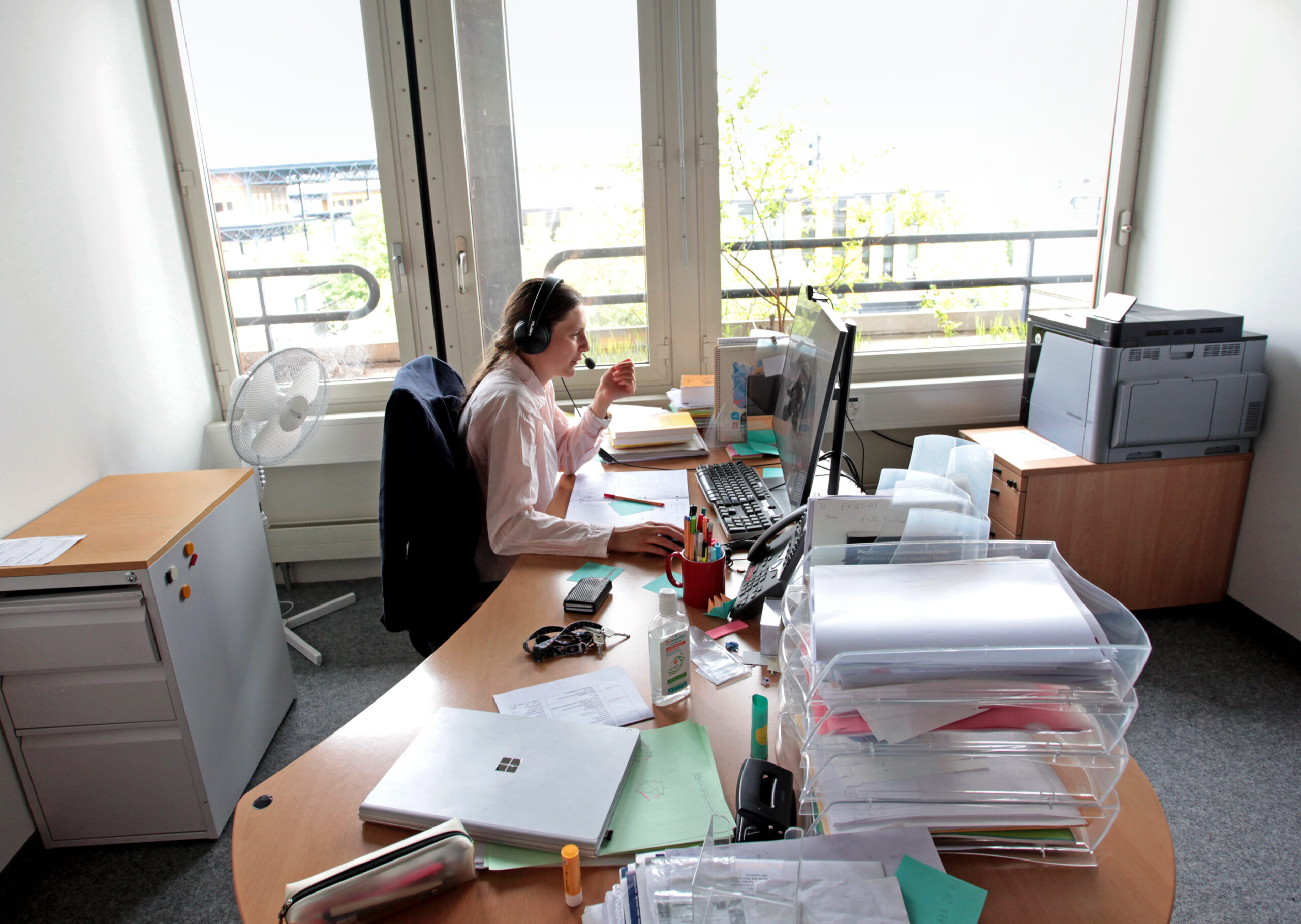 Maryna Viazovska seated at her office desk using her computer to videoconference with students.