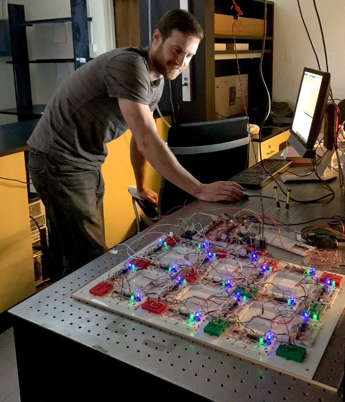 A man looks at a glowing circuit.