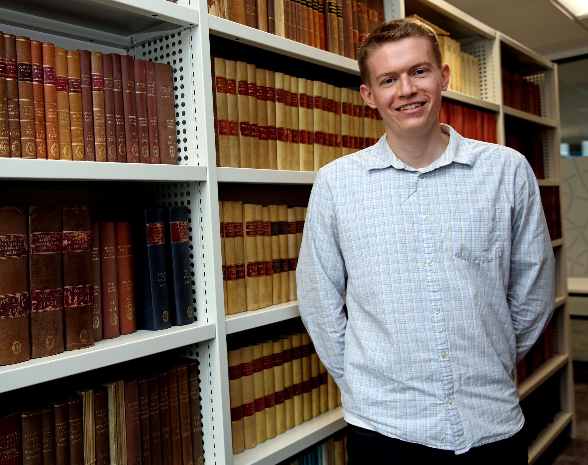 A man in front of a bookshelf.