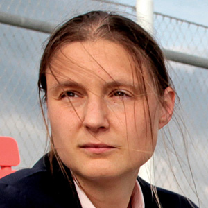 Maryna Viazovska seated on the wooden steps of an amphitheater at the Swiss Federal Institute of Technology Lausanne.