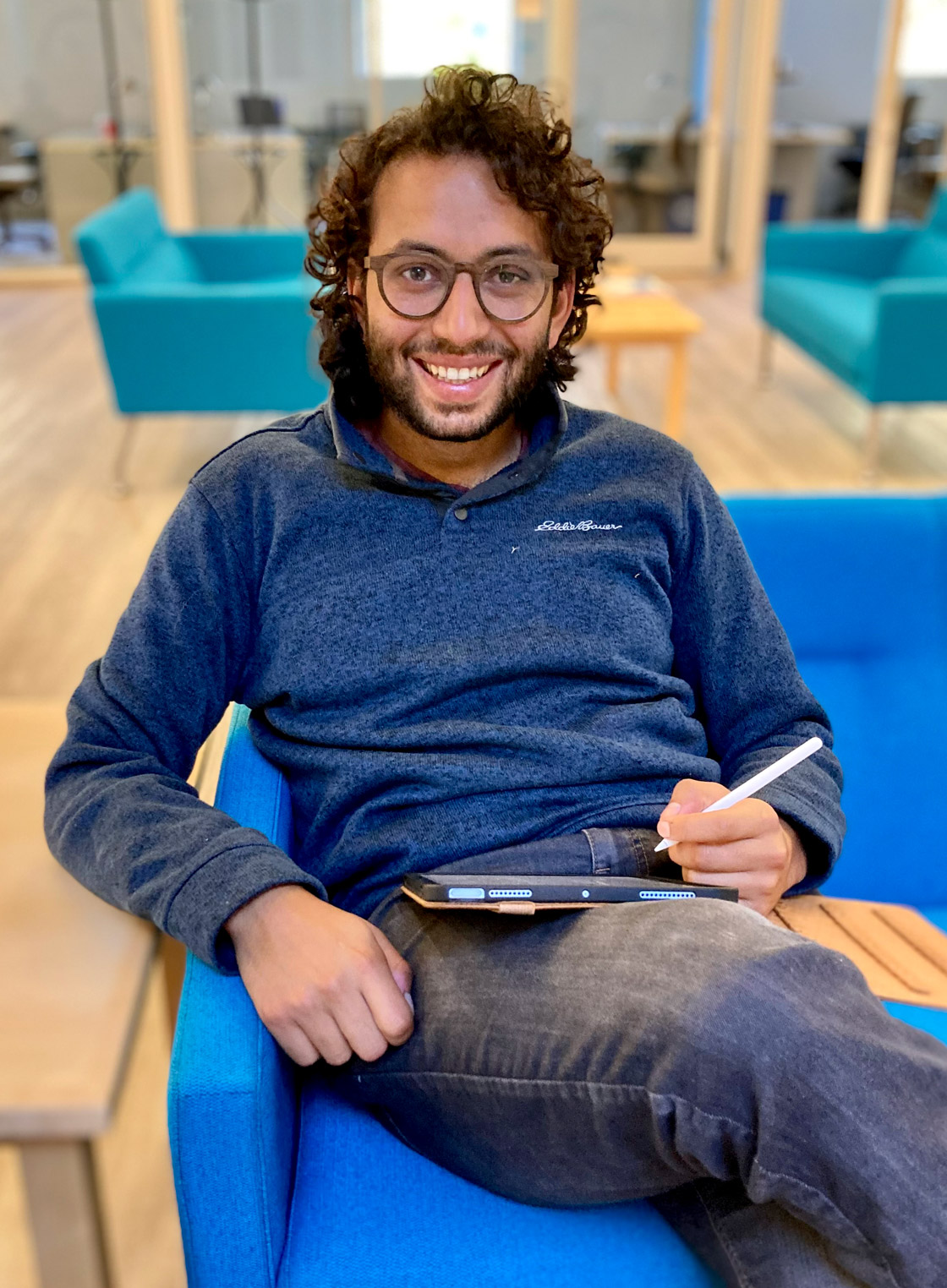 Chinmay Nirkhe sits on a blue chair.