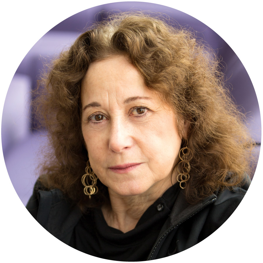 a portrait of a light-skinned woman with brown curly hair, a black shirt, and gold earrings