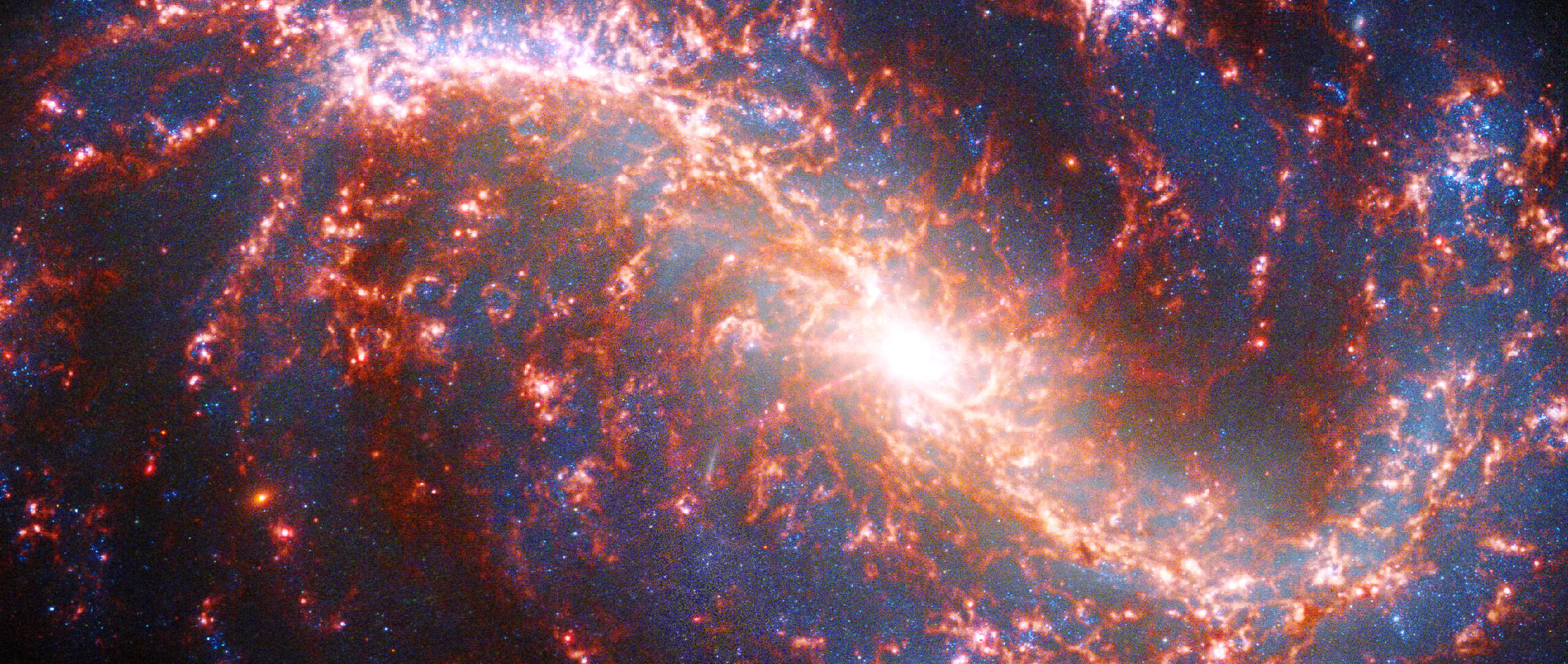 Image of a spiral galaxy strewn with ribbons of pink light.]