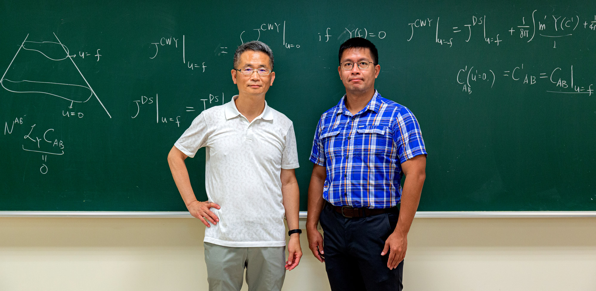 Two men working at a blackboard.