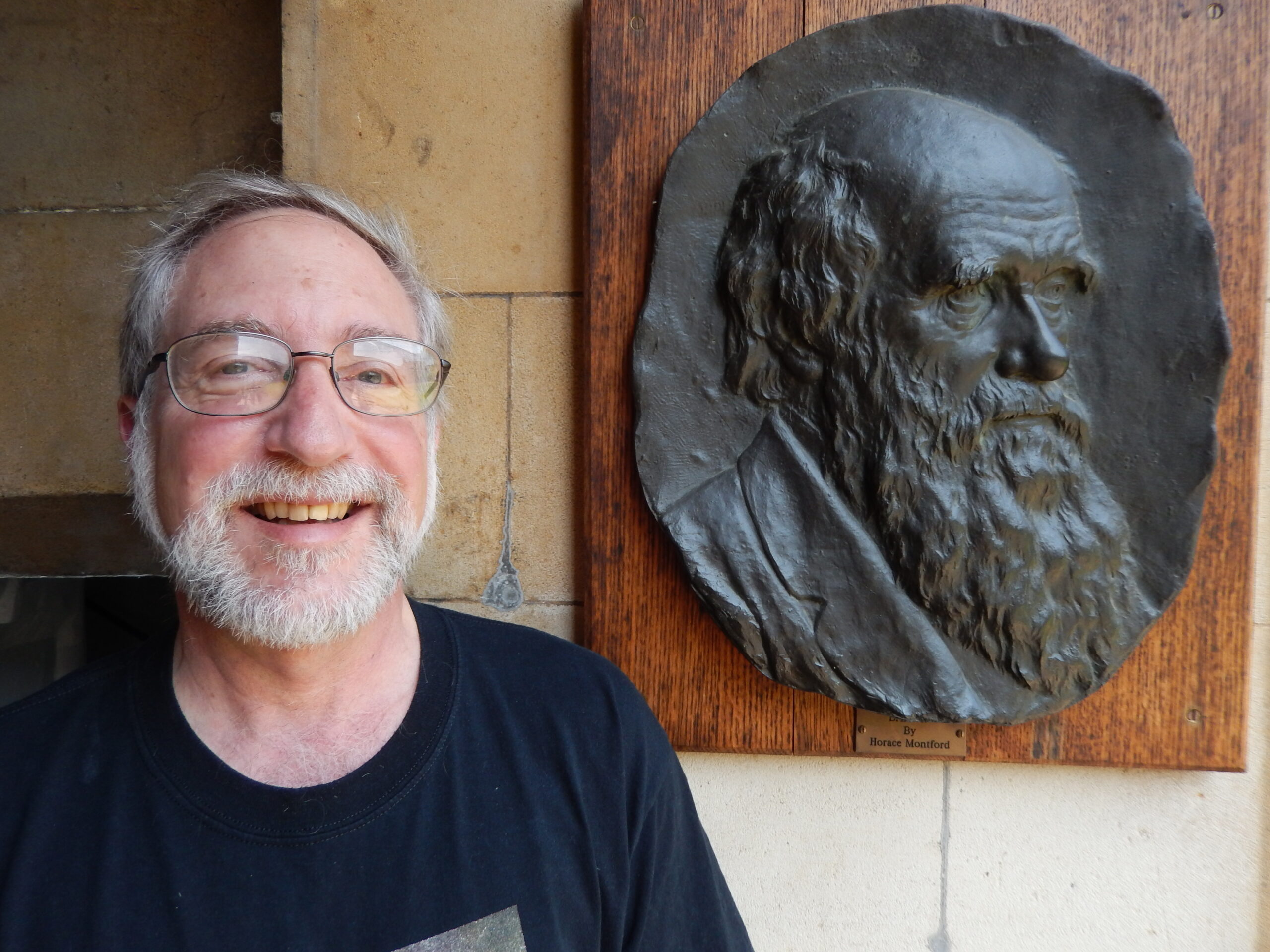 Researcher Harold Zakon of the University of Texas, Austin, standing near a relief sculpture of Charles Darwin.