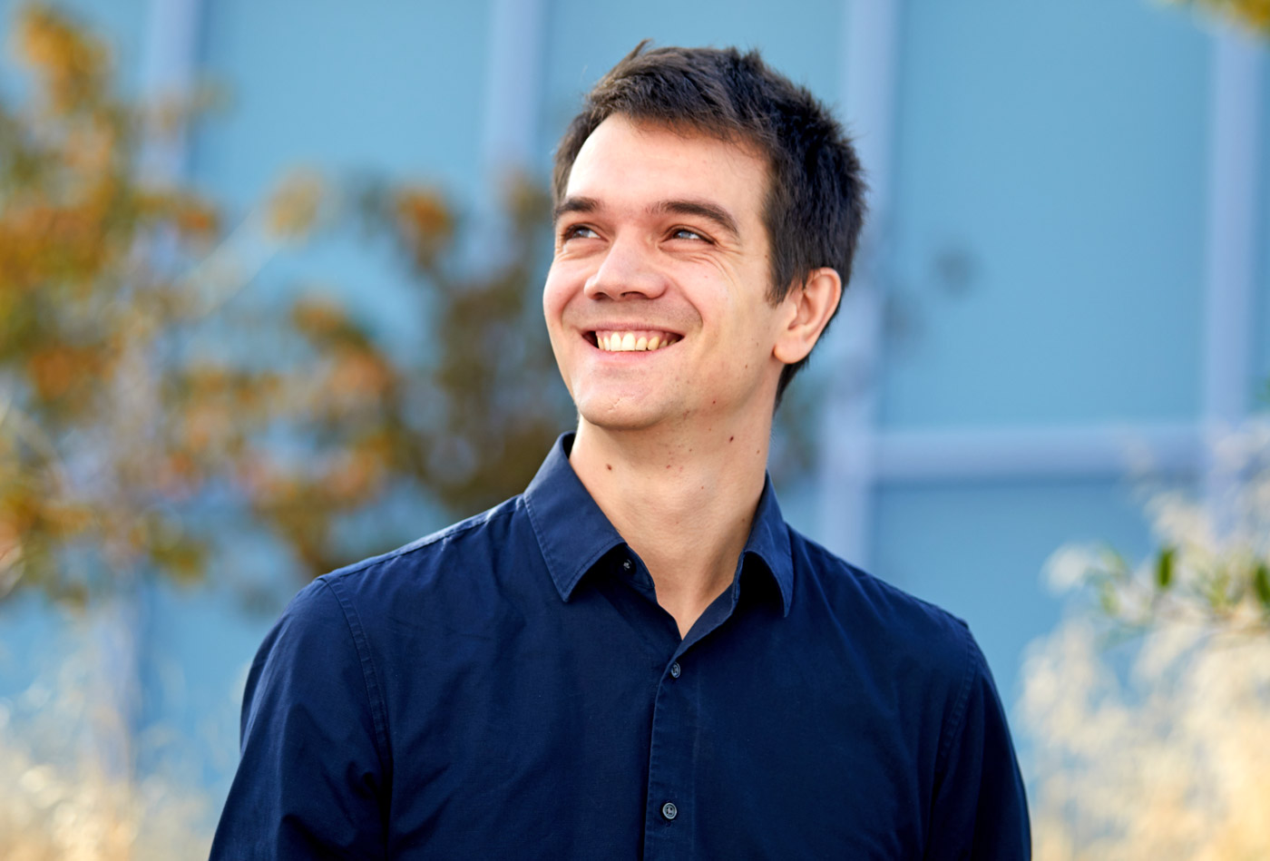 Alt: Jean-Rémi King in a dark blue shirt outdoors