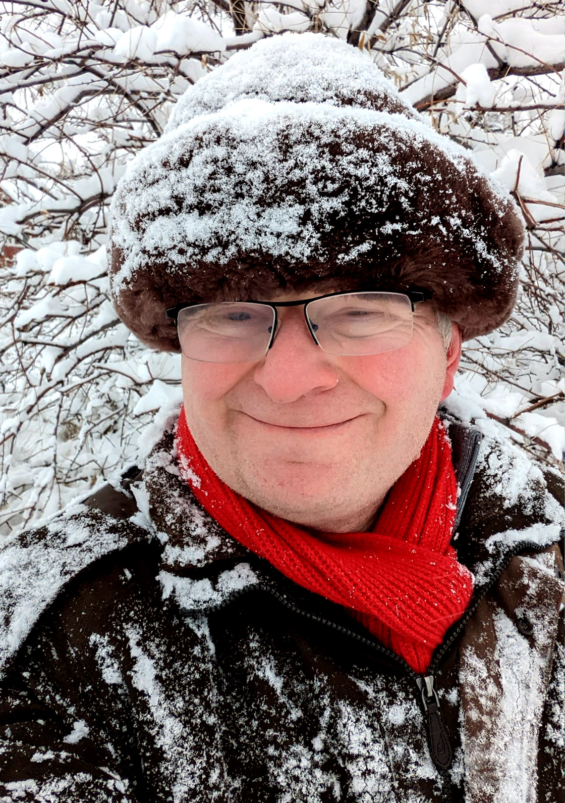 Alexei Efros in a red scarf and furry hat covered in snow