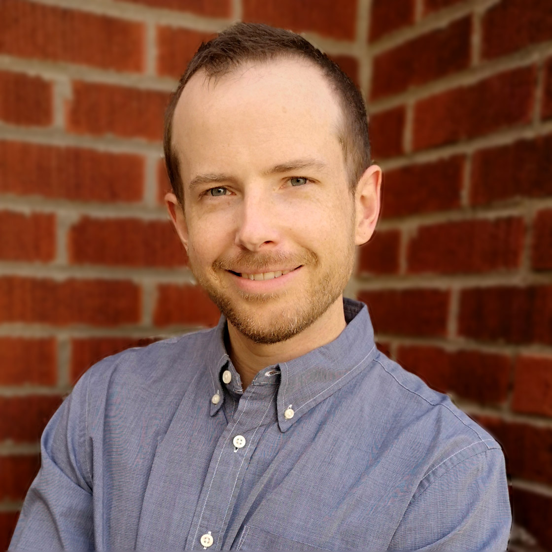 Blake Richards in a blue shirt in front of a brick wall