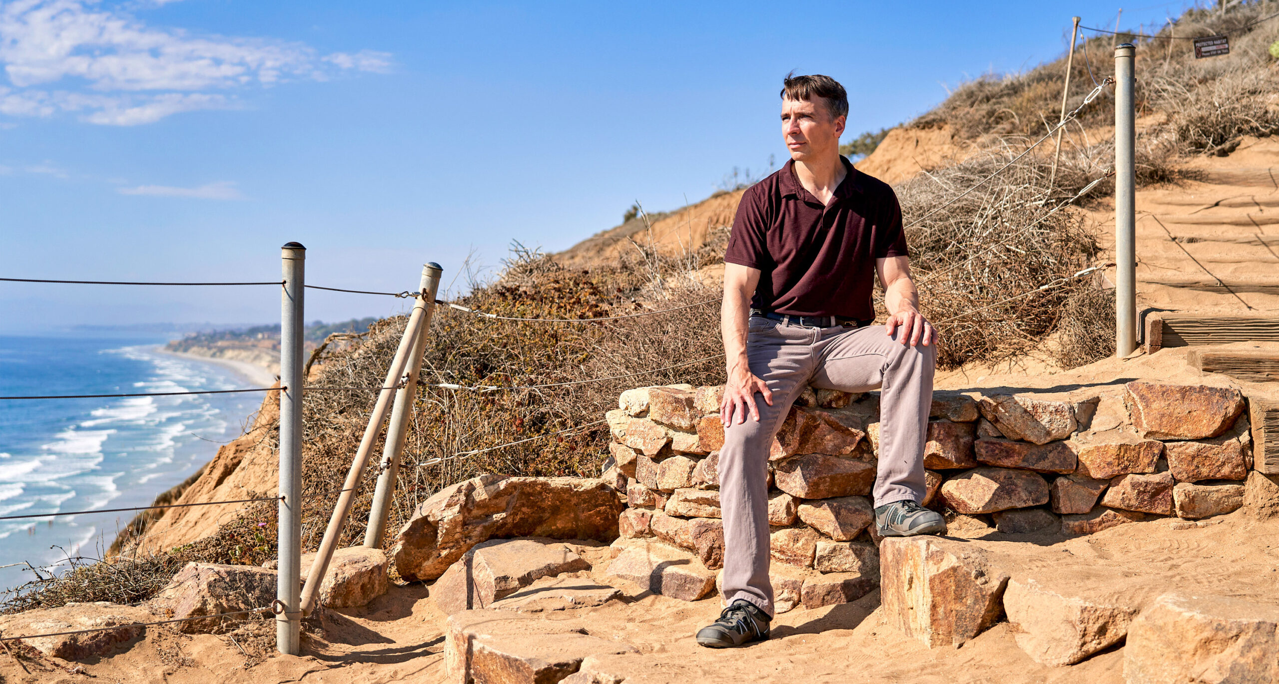 Richard Rusczyk looking out at the Pacific Ocean while sitting in Torrey Pines State Natural Reserve in San Diego.