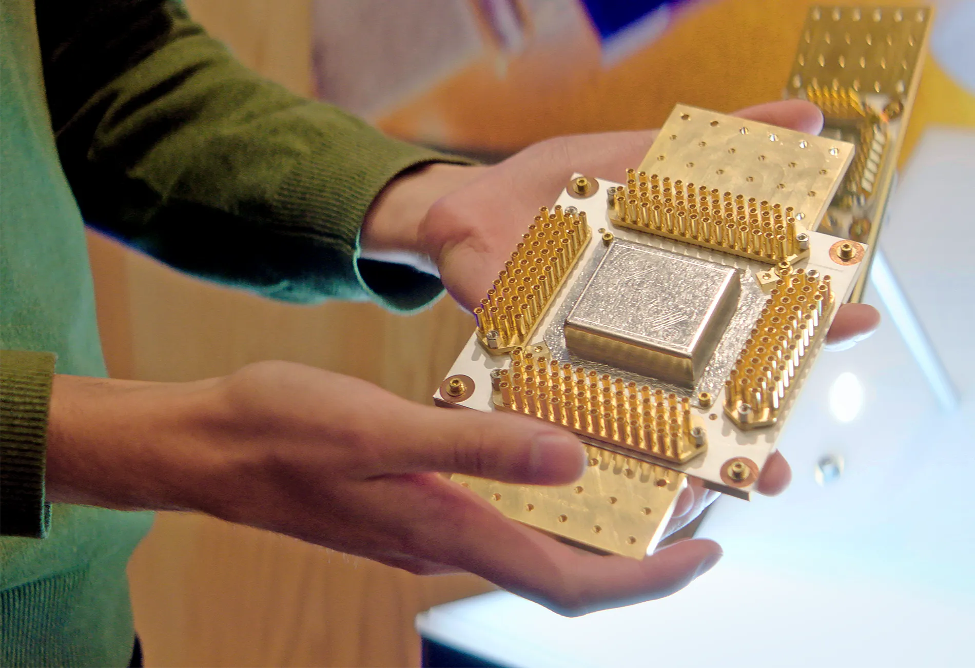 A close-up of hands holding a gold and silver device.