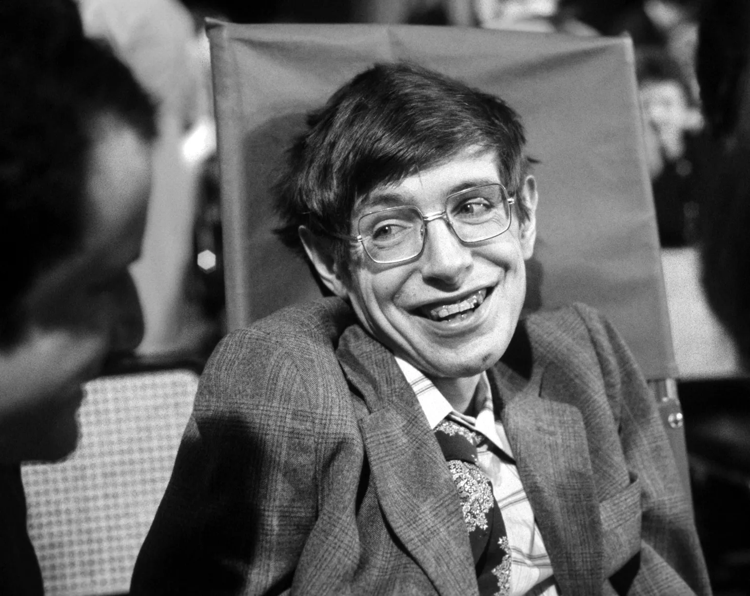 Black-and-white photo of Stephen Hawking smiling.