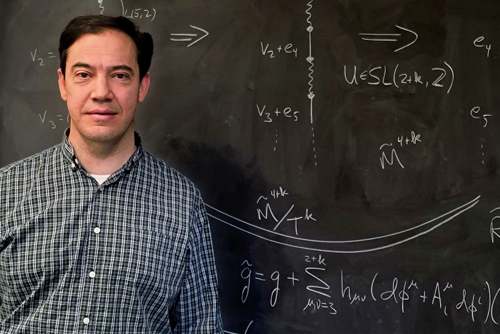 Marcus Khuri in front of a chalkboard.