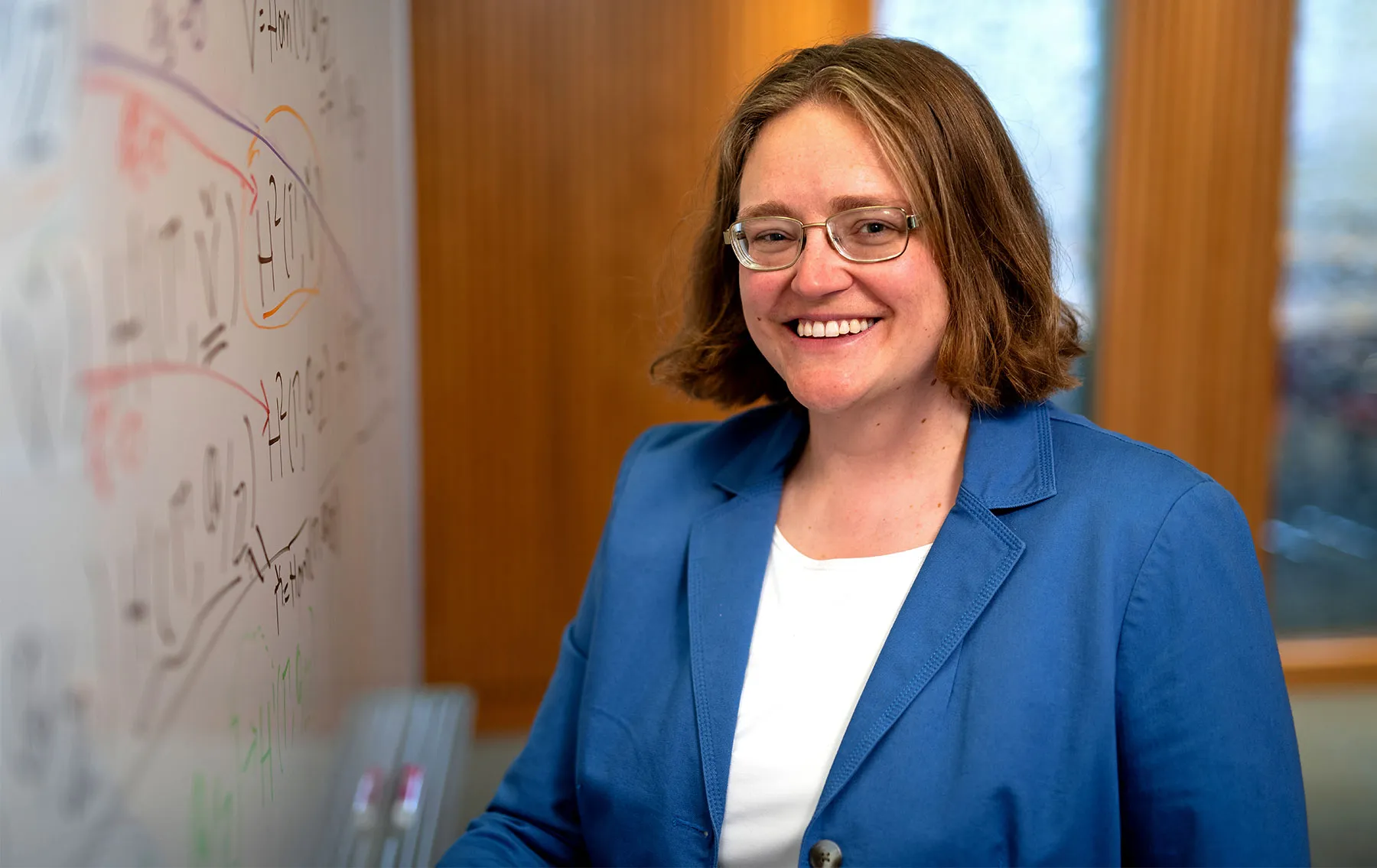 Professor Melanie Matchett Wood of Harvard University stands before a whiteboard filled with equations.