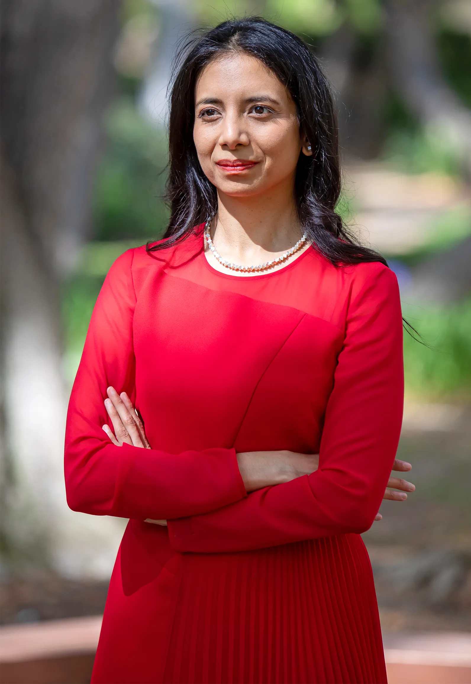 Anima Anandkumar standing outside in a red dress