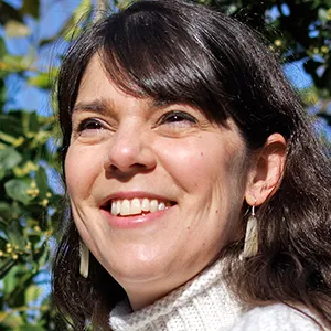 Researcher Kristy Red Horse holding a model of a human heart, with a lemon tree behind her.