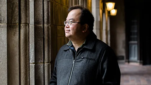 Mathematician Lek-Heng Lim standing near some columns at the University of Chicago.