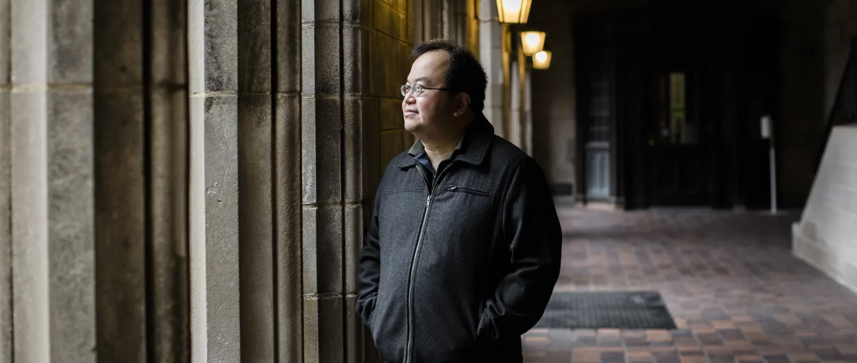 Mathematician Lek-Heng Lim standing near some columns at the University of Chicago.