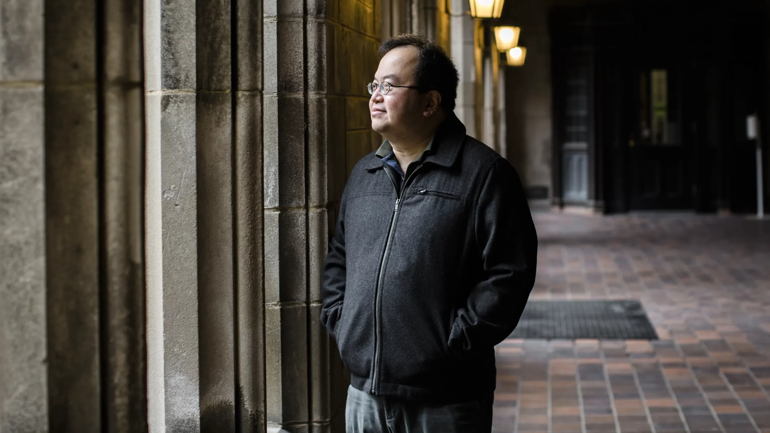 Mathematician Lek-Heng Lim standing near some columns at the University of Chicago.