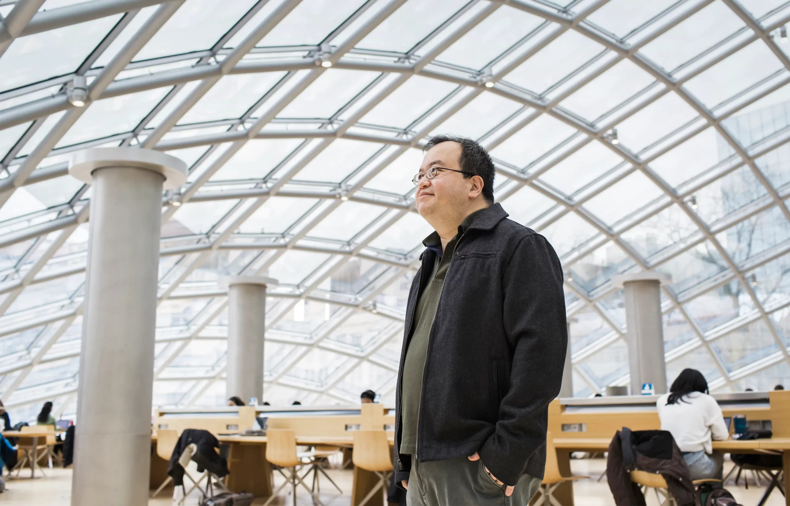 Lim standing inside a glass-roofed building at the University of Chicago.