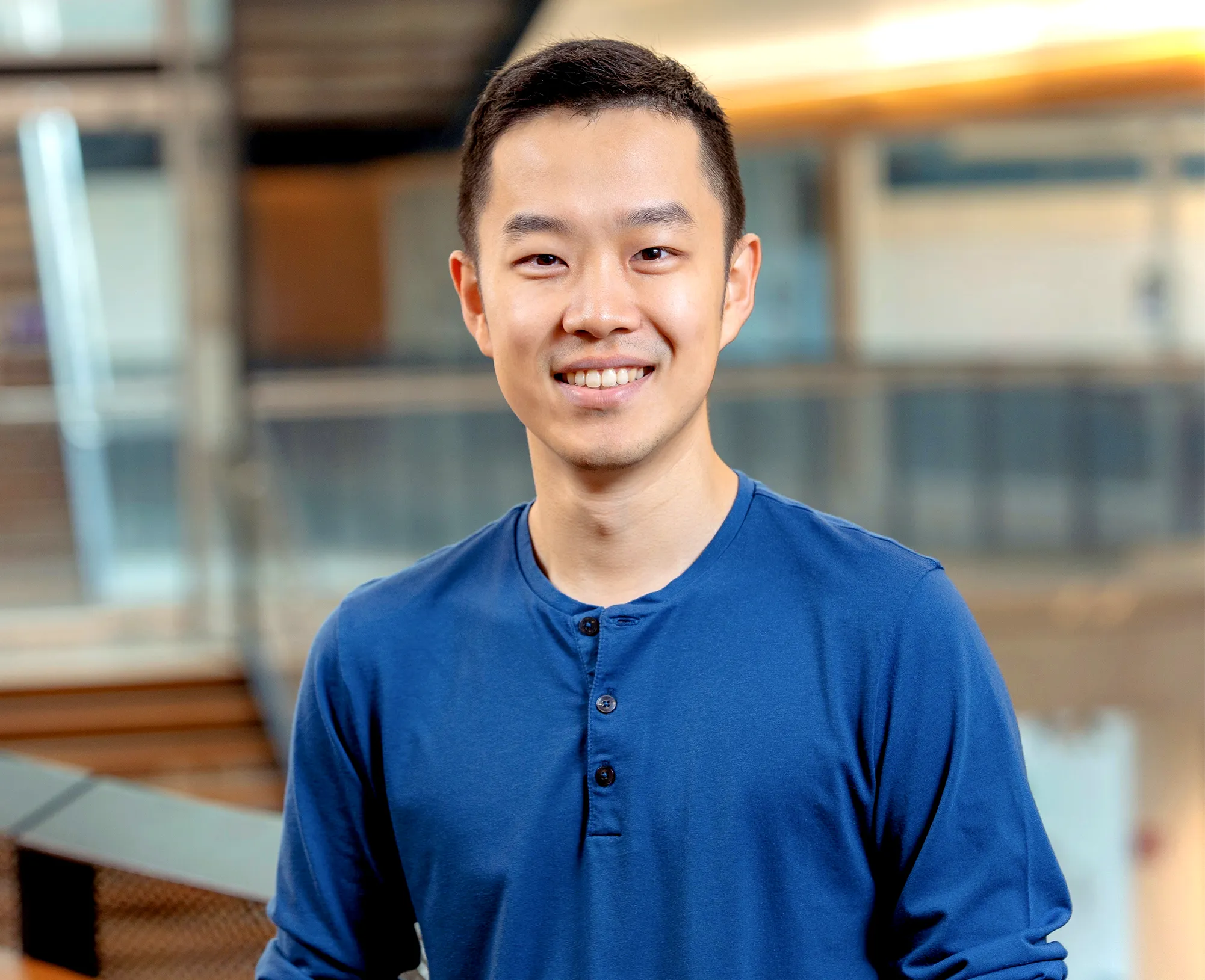 Victor Zhong in a blue shirt in front of staircases