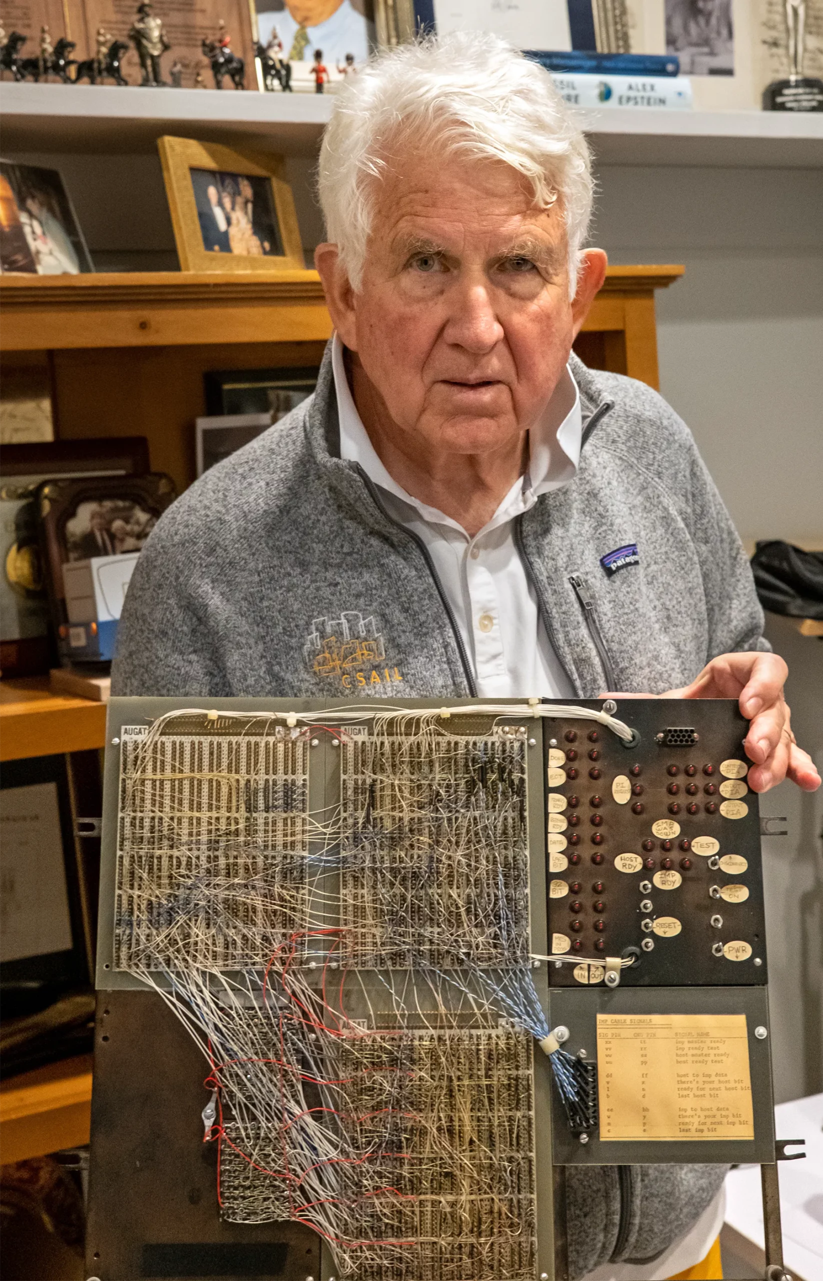 Bob Metcalfe holds up a board with wires and lights going everywhere.