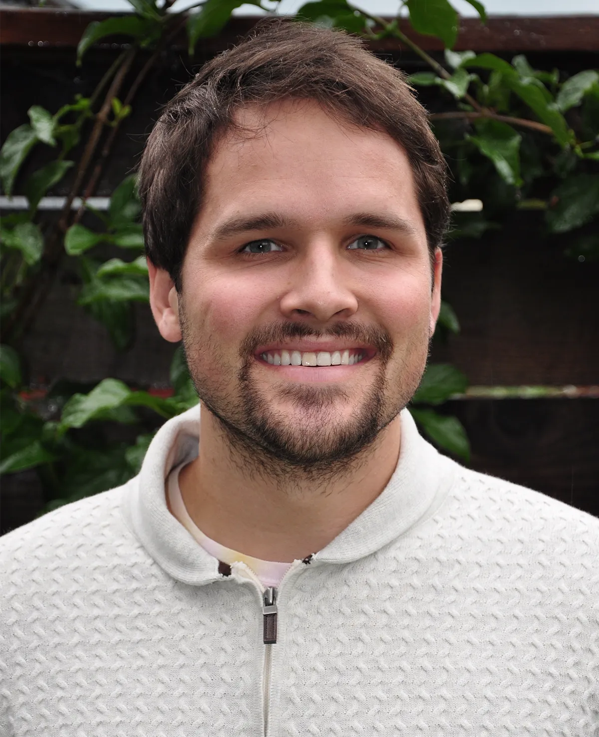 Headshot of Corbett-Detig against greenery.