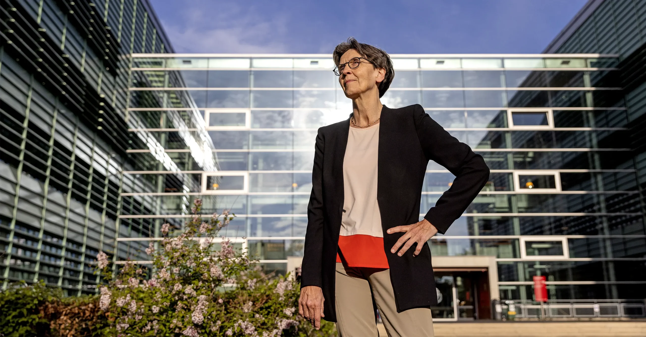 Loll stands in front of a wall of windows at Radboud University.